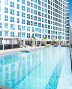 a large swimming pool in front of a tall building at Apartamento con piscina infinita frente al mar en Avenida Balboa PH The Sand in Panama City