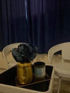 żółta waza z rośliną na tacy w obiekcie شقق وغرف خاصة w mieście Ha'il