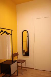 ナポリにあるA Casa Nostraの鏡と椅子とランプ付きの部屋