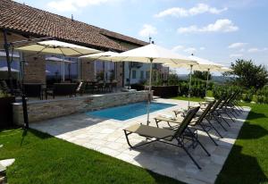 - un groupe de chaises longues et de parasols à côté de la piscine dans l'établissement Casa Faretto, à Costigliole dʼAsti