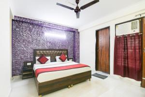 een slaapkamer met een bed en een paarse muur bij Hotel River Front in New Delhi