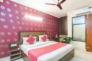 een slaapkamer met een groot bed met een paarse muur bij Hotel River Front in New Delhi