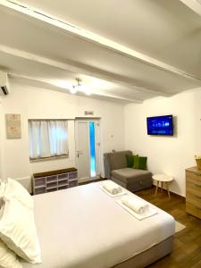 a bedroom with a white bed and a couch at Apartments Bajkovic in Kotor