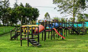 a playground with colorful play equipment in a park at Cabaña Maribel encanto in Filandia
