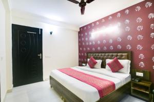een slaapkamer met een bed met een rode muur bij Hotel River Front in New Delhi