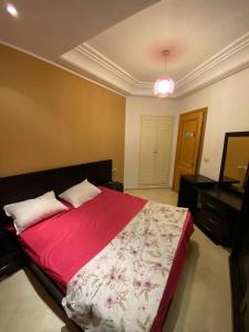 蘇塞的住宿－Magnifique Appartement S1 a sousse，一间卧室配有一张带红色毯子的大床