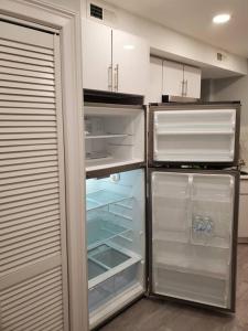 an empty refrigerator with its door open in a kitchen at Casa Bella in North Bergen
