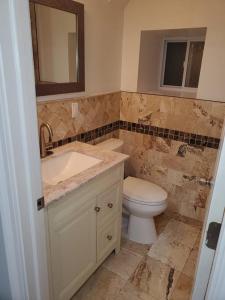 a bathroom with a toilet and a sink and a mirror at Casa Bella in North Bergen