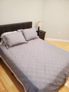a large bed in a bedroom with a night stand at Casa Bella in North Bergen