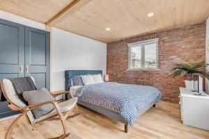 ein Schlafzimmer mit einem Bett und einer Ziegelwand in der Unterkunft Initial / Bonjour / Chutes-Montmorency in Boischâtel