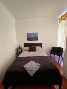 a bedroom with a large bed and a chair at Galápagos Brunette Suites in Puerto Ayora