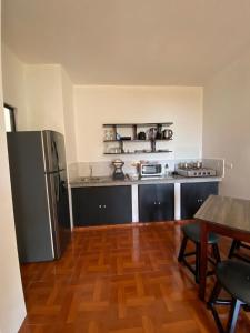 a kitchen with a stainless steel refrigerator and a table at Galápagos Brunette Suites in Puerto Ayora