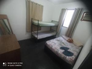 ein kleines Zimmer mit einem Bett mit Hut darauf in der Unterkunft A casa amarela in Cabo Frio