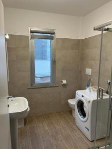 ein Badezimmer mit einer Waschmaschine neben einem WC in der Unterkunft Appartamento La Lupa in Piacenza