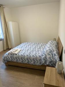 Schlafzimmer mit einem Bett mit blauer Decke in der Unterkunft Appartamento La Lupa in Piacenza