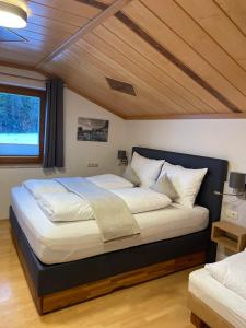 ザールフェルデン・アム・シュタイナーネン・メアーにあるLandhaus Bruggerの木製の天井のベッドルームの大型ベッド1台