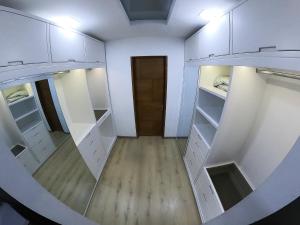 einen leeren begehbaren Kleiderschrank mit weißen Schränken und einer Tür in der Unterkunft Habitación de lujo in Bogotá