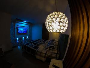 ein Schlafzimmer mit einem Bett und einer großen Leuchte in der Unterkunft Habitación de lujo in Bogotá