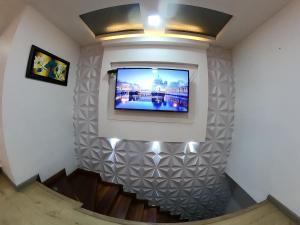 einen TV an der Wand in einem Zimmer mit Treppen in der Unterkunft Habitación de lujo in Bogotá
