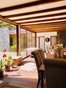 een woonkamer met een houten plafond en een tafel bij Refugio Los Coigües in Puerto Varas