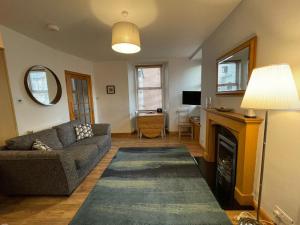 a living room with a couch and a fireplace at Rose Cottage, Fishertown in Nairn