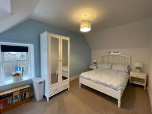 a bedroom with a bed and a window at Rose Cottage, Fishertown in Nairn