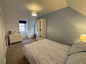 a bedroom with a bed and a cabinet and a window at Rose Cottage, Fishertown in Nairn