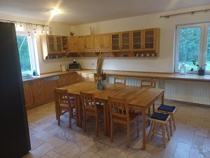 uma grande cozinha com uma mesa de madeira e cadeiras em Dwór pod Sosnami Kaszuby em Ostrzyce