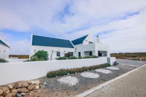 a white house with a blue roof at Sandals & Seashells in Jacobs Bay +6 photos
