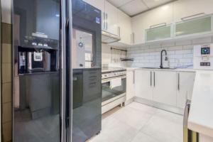 ドバイにあるJbr Sea View Captivating 4-Bed Apartment in Dubaiのキッチン(ステンレス製の冷蔵庫、シンク付)