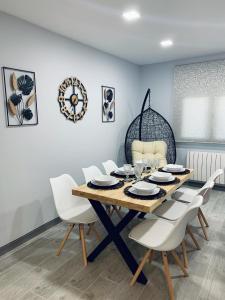 comedor con mesa de madera y sillas blancas en Apartamentos Buganvilla en Alhama de Aragón