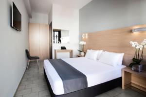 Habitación de hotel con cama y silla en Atlas Suites en Skíathos