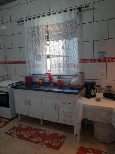 a kitchen with a sink and a stove at Casa Azul-Paraíso em Búzios in Búzios