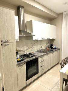 una cucina con lavandino e piano cottura forno superiore di B&B VIRGILIO LAMEZIA AIRPORT a SantʼEufemia Lamezia