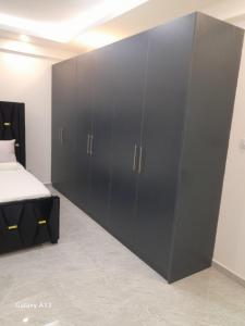 Nice view apartment في مومباسا: خزانة سوداء كبيرة في غرفة مع سرير