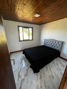 1 dormitorio con 1 cama negra en una habitación en Casa a estrenar 450 metros de la playa en Quequén