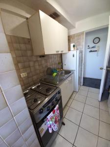 a small kitchen with a stove and a refrigerator at Excelente ubicación in Concón