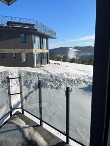 een uitzicht op een met sneeuw bedekt balkon van een gebouw bij Zimska idila Divcibare in Divčibare