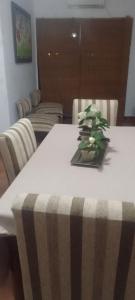 Una mesa blanca con un jarrón de flores. en Alojamiento Las Camelias en Concordia