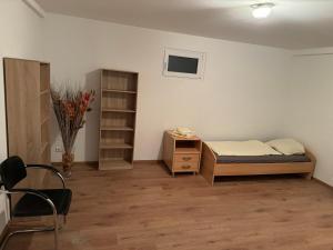 a bedroom with a bed and a desk and a chair at Souterrainwohnung Offenburg in Offenburg