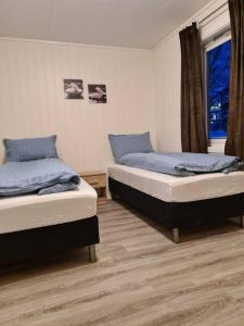 2 camas individuales en una habitación con ventana en Tromsø stunning Luxury apart B, en Tromsø