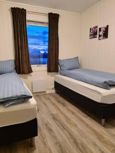 2 camas en una habitación con ventana en Tromsø stunning Luxury apart B, en Tromsø