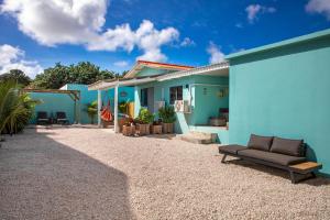 a blue house with a couch in front of it at Playa Feliz Apartments Bonaire in Kralendijk