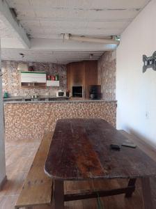 a wooden table in a room with a kitchen at Hostel BSJ in Casimiro de Abreu