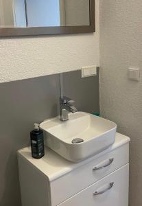 a bathroom sink with a mirror on top of a dresser at Souterrainwohnung Offenburg in Offenburg