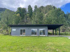 una pequeña casa en un campo con árboles en el fondo en Cabaña Azul, en Riñinahue