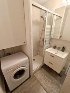 a small bathroom with a washing machine and a sink at Appartement Centre port 4 pers Cap d'Agde in Cap d'Agde