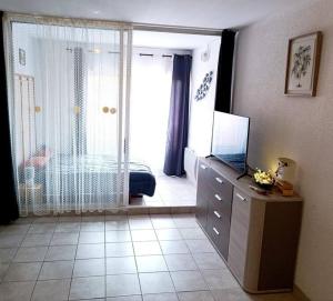 a room with a bedroom with a television on a dresser at Appartement Centre port 4 pers Cap d'Agde in Cap d'Agde