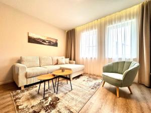a living room with a couch and a chair at Hotel Tyrapol - Smrek Apartments in Oravská Lesná