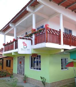 un edificio con balcón y una señal en él en Belo Bay Apartment Hotel, en Portobelo